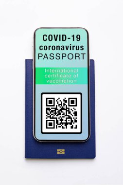 COVID-19 için sağlık ya da aşı pasaportu erkeklerin elinde bulunan fotokopi cihazında sergileniyor. Dijital Covid-19 Sağlık Sertifikası kişinin aşılandığını kanıtlıyor