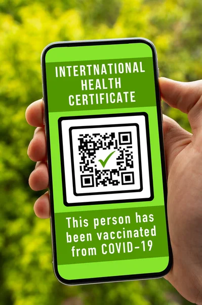 Traveler shows international health passport of vaccination certification on phone to certify that have been vaccinated of coronavirus. Travel without restrictions concept, vertical image