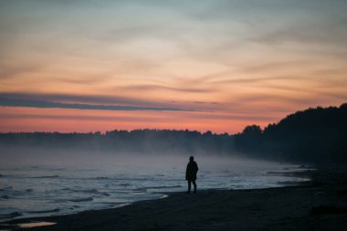 Gün batımında sahilde bir adam.