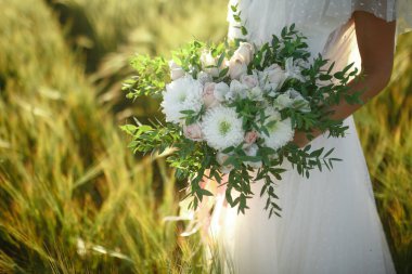 Gelinin elinde düğün buketi.