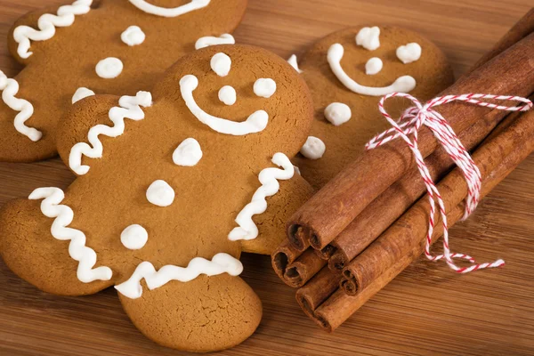 Freshly baked gingerbread man cookies and cinnamon sticks — Stock Photo, Image