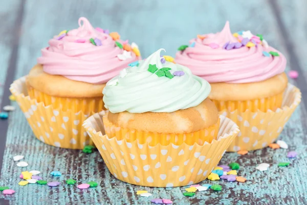 Pastel cupcakes com polvilhas no fundo do vintage azul — Fotografia de Stock