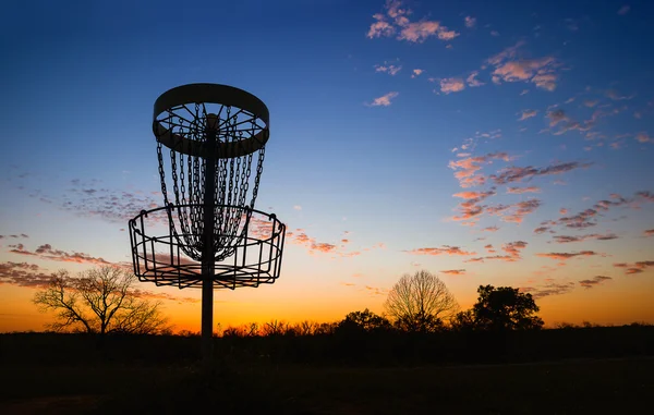 Silhouette de panier de golf à disque contre le coucher du soleil — Photo