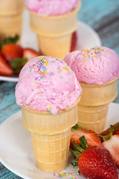 Клубничное мороженое с брызгами в вафельных чашках — стоковое фото