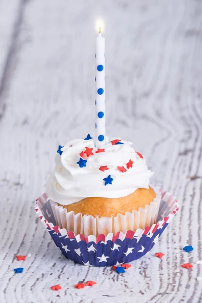 Cupcake patriótico del 4 de julio con una vela Imagen de archivo