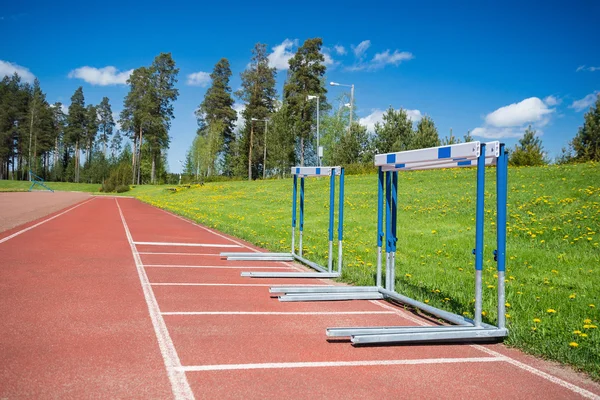 Hurdles stacked at the edge of running track — ストック写真