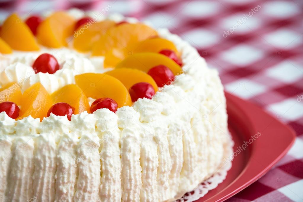 Homemade cream cake with peaches and cherries 