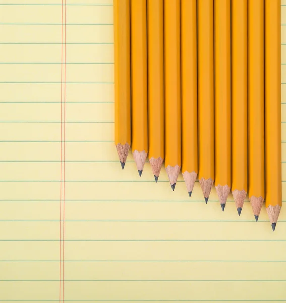行的黄色铅笔在笔记本上 — 图库照片