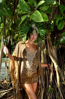 Model tropikal ağacın önünde poz 