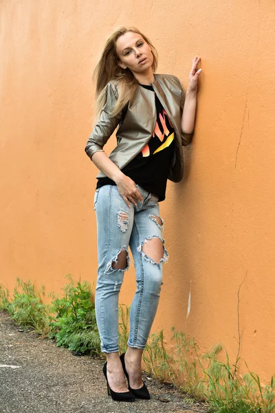 Woman in jacket and ripped jeans — Stock Photo, Image