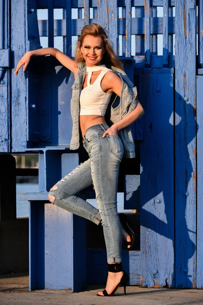 Woman in ripped jeans and denim vest — Stock Photo, Image