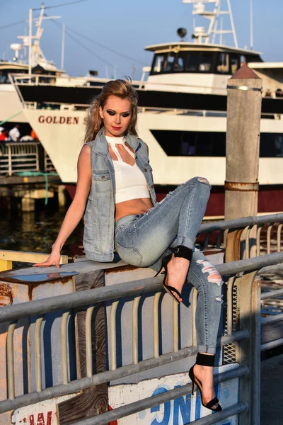 Woman in ripped jeans and denim vest — Stock Photo, Image
