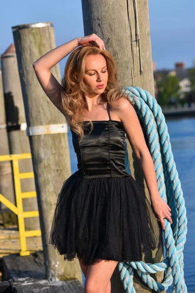 Модель в чорній сукні насолоджується сонячним світлом — стокове фото