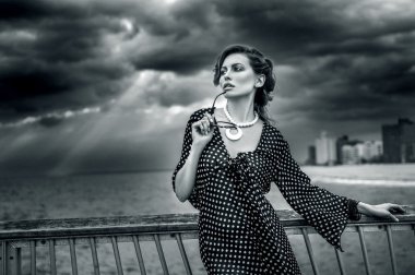 Romantik siyah beyaz elbise ve güneş gözlüğü giyen genç kadın portresi