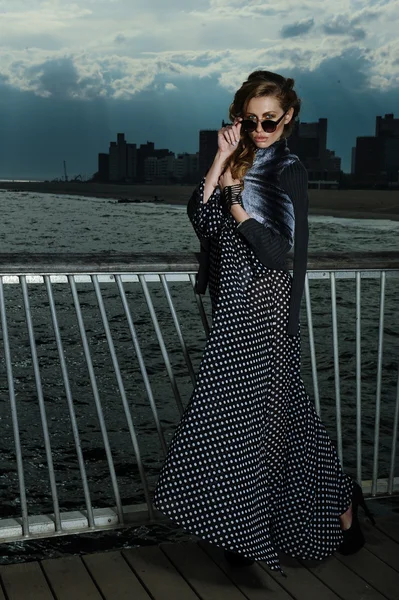 Aantrekkelijke jonge vrouw dragen zwart-wit maxi jurk, poseren op de Pier — Stockfoto