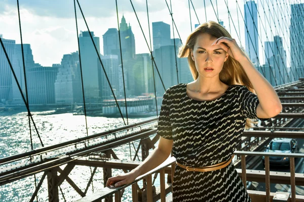 Retrato de metade do comprimento de uma modelo feminina loira atraente em pé na ponte de Brooklyn — Fotografia de Stock