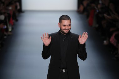 Tasarımcısı Michael Costello Michael Costello defilede seyirci selamlıyor