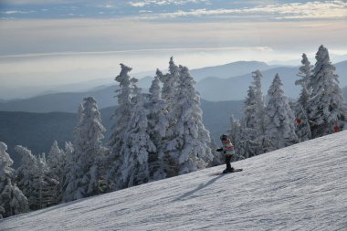 Mansfield 4393 feet zirvesindeki Octagon kafe gözlem güvertesinden kayakçılarla kayak pistlerine panoramik manzara - Stowe Kayak merkezi, VT