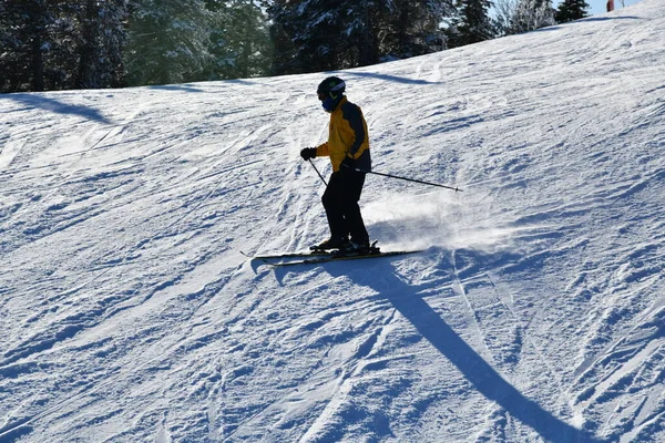 晴れた日に下り坂を行うスキーヤーストウ山スキー場で新鮮な雪 — ストック写真