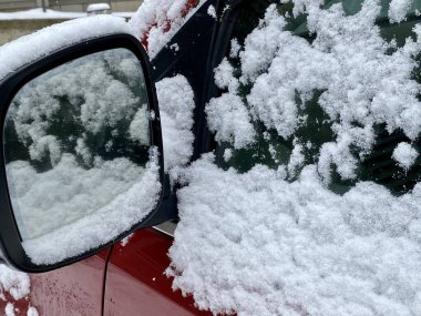 Aralık ayı başında Vermont, ABD 'de kar yağışı sonrasında kırmızı araba pencerelerinin tepesinde taze kar ve kar taneleri 