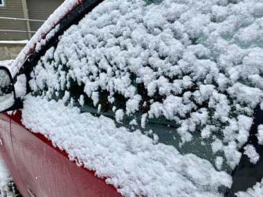 Aralık ayı başında Vermont, ABD 'de kar yağışı sonrasında kırmızı araba pencerelerinin tepesinde taze kar ve kar taneleri 