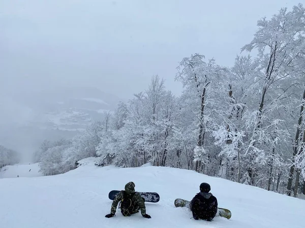 ストウ山スキー場の美しいパノラマの谷を見下ろす歩道に座っているスノーボーダー — ストック写真