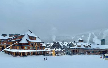 Panoramic view to the Stowe Mountain resort Spruce peak village at evening time early December 2020 Vermont, USA clipart