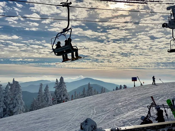 ストウ山スキー場での美しい晴れた日バーモントスキーリフトでのスキーヤーのシルエット 12月2020 — ストック写真