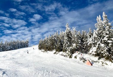 Güzel güneşli bir kar günü mavi gökyüzü ve bulutlarla Stowe Dağı Kayak merkezi Vermont 'ta - Aralık 2020