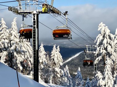 Vermont 'taki güneşli kış gününde Okemo dağ kayak merkezinde kayak koltuğu kaldırılıyor.