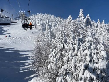 Vermont 'taki güneşli kış gününde Okemo dağ kayak merkezinde kayak koltuğu kaldırılıyor.