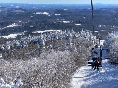 Vermont 'taki güneşli kış gününde Okemo dağ kayak merkezinde kayak koltuğu kaldırılıyor.