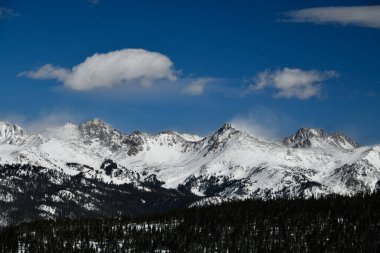 Güneşli bir günde Vail, Colorado 'da beyaz bulutların olduğu dağlara panoramik bir manzara