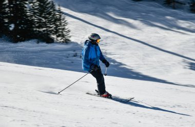 Kayakçı, güneşli bir günde Vail Kayak Merkezi, Colorado 'da yüksek hızda aşağı iniyor.
