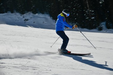 Kayakçı, güneşli bir günde Vail Kayak Merkezi, Colorado 'da yüksek hızda aşağı iniyor.