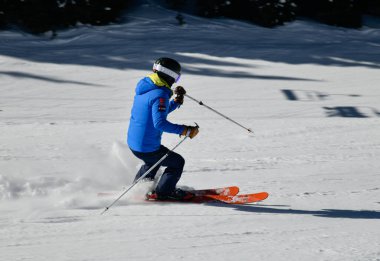 Kayakçı, güneşli bir günde Vail Kayak Merkezi, Colorado 'da yüksek hızda aşağı iniyor.