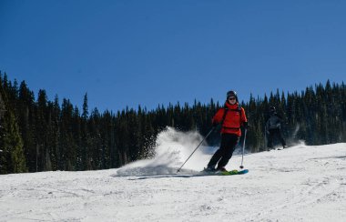 Kayakçı, güneşli bir günde Vail Kayak Merkezi, Colorado 'da yüksek hızda aşağı iniyor.