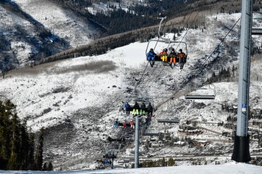 Kayakçılar ve snowboardcularla kayak koltuğu kaldırma. Vail, Colorado, ABD 'deki kayak merkezi.