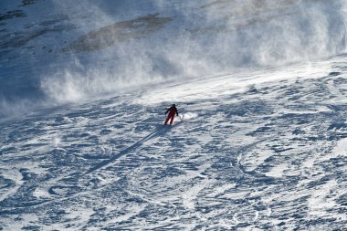 Kırsal bölgede kayak yapan parlak kırmızı takım elbiseli bir adam. Aşırı kış sporları. Breckenridge, Colorado İmparatorluk kase bölgesinde.