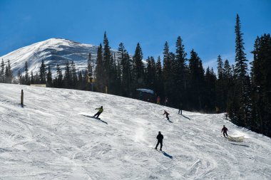 İnsanlar Breckenridge Kayak Merkezi 'ndeki kar tepesinde kayak ve snowboard yapıyor. Aşırı kış sporları. Aksiyon atışı. Breckenridge, komutan.