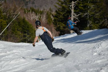 İki snowboardcu Nisan ortasında Vermont 'taki Stowe Dağı tatil köyünde güneşli bir günde görüldü..