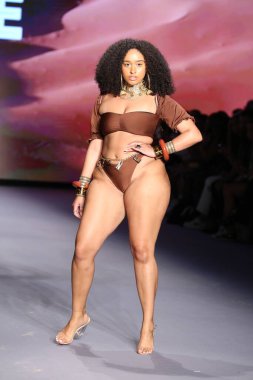 MIAMI BEACH, FLORIDA - 09 Temmuz 2021 'de Miami Beach, Florida' da bir model Bfyne Runway Show için podyumda yürüyor..