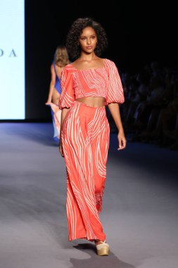 MİAMİ BEACH, FLORIDA - 08 Temmuz 2021 'de Miami Beach, Florida' da Paraiso Miami Sahili 'nde Smeralda Show' u sunan bir model DESTINATION Kolombiya podyumunda yürüyor..