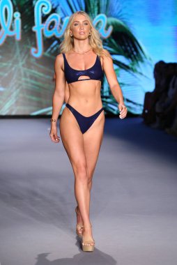 MIAMI BEACH, FLORIDA - 10 Temmuz 2021 'de Miami Beach, Florida' da Paraiso Miami Sahili 'nde Luli Fama için bir model podyumda yürüyor..