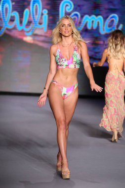MIAMI BEACH, FLORIDA - 10 Temmuz 2021 'de Miami Beach, Florida' da Paraiso Miami Sahili 'nde Luli Fama için bir model podyumda yürüyor..