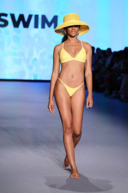 MIAMI BEACH, FLORIDA - 10 Temmuz 2021 'de Miami Beach, Florida' daki Paraiso Çadırı 'ndaki Miami Yüzme Haftası' nda Style Group Collective tarafından yapılan Yaşam sırasında bir model podyumda yürüyor..