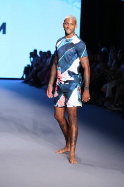 MIAMI BEACH, FLORIDA - 10 Temmuz 2021 'de Miami Beach, Florida' daki Paraiso Çadırı 'ndaki Miami Yüzme Haftası' nda Style Group Collective tarafından yapılan Yaşam sırasında bir model podyumda yürüyor..