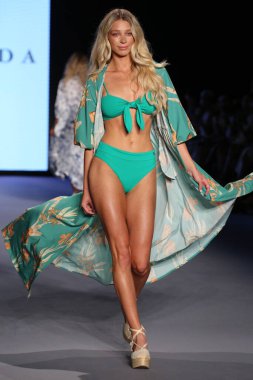 MİAMİ BEACH, FLORIDA - 08 Temmuz 2021 'de Miami Beach, Florida' da Paraiso Miami Sahili 'nde Smeralda Show' u sunan bir model DESTINATION Kolombiya podyumunda yürüyor..