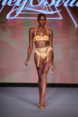 MIAMI BEACH, FLORIDA - 10 Temmuz 2021 'de Miami Beach, Florida' daki Paraiso Çadırı 'nda Bal Birdette için Miami Yüzme Haftası' nda bir model podyumda yürüyor..