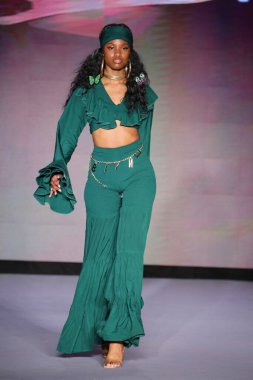 MIAMI BEACH, FLORIDA - 09 Temmuz 2021 'de Miami Beach, Florida' da bir model Bfyne Runway Show için podyumda yürüyor..